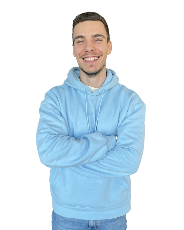 Luca Klopfer lächelt freundlich in einem blauen Hoodie und zeigt eine positive Körperhaltung.